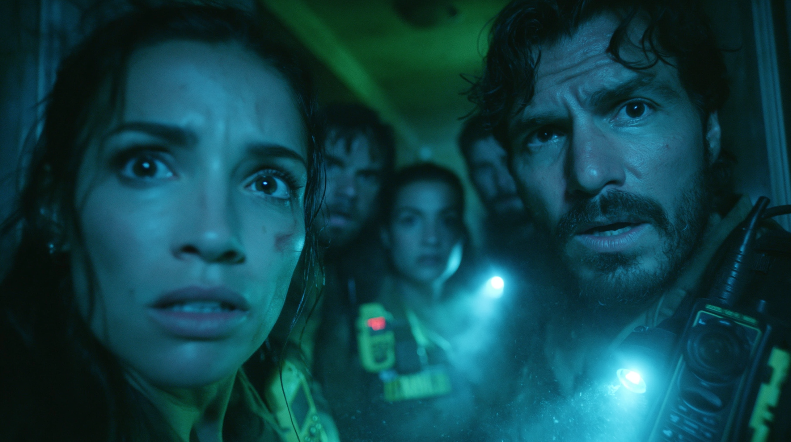 Equipe de investigadores paranormais usando equipamento especializado em ambiente assombrado escuro